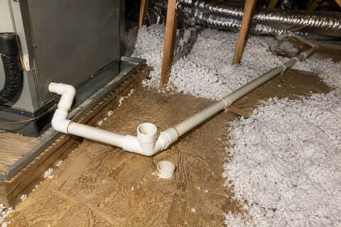 Condensate drain line with an open cleanout tee beside an air handler cabinet in an attic