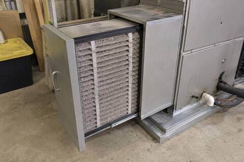 Deep media filter cabinet beside an air handler with the pleated cartridge pulled half way out