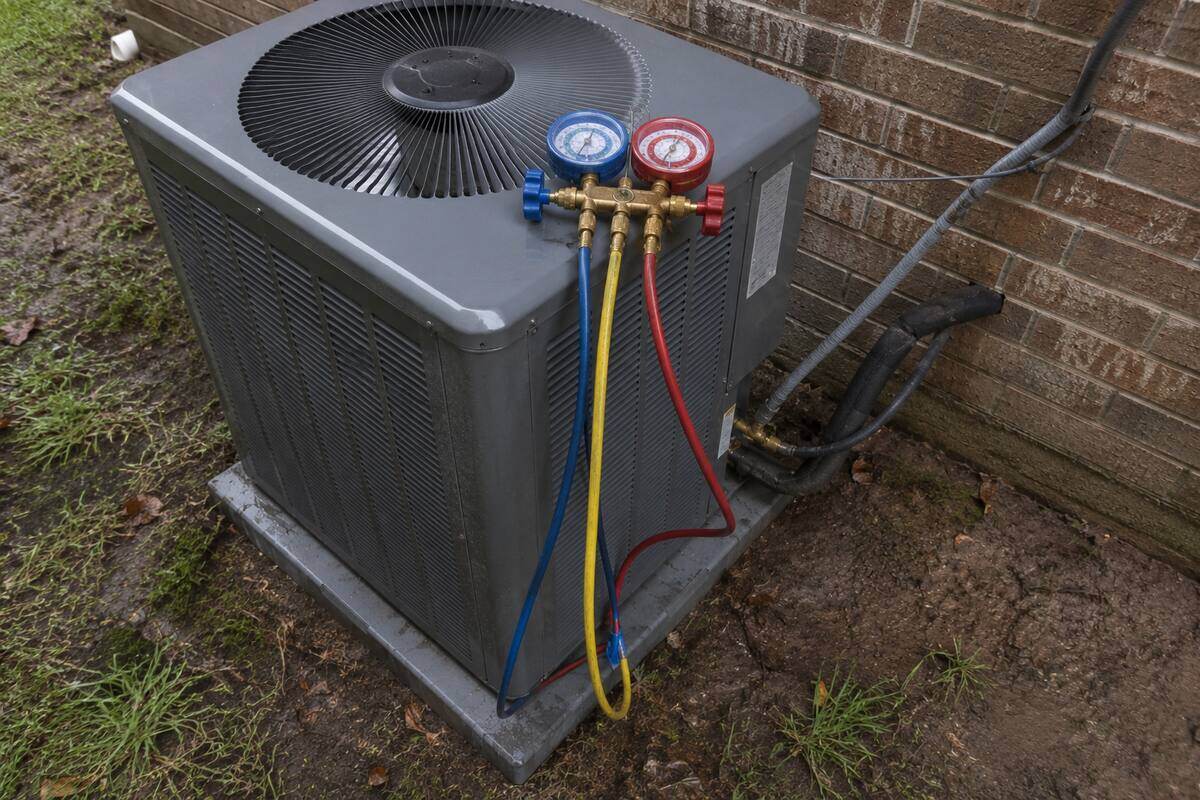 Refrigerant manifold gauge set with hoses connected to the service ports on an outdoor unit